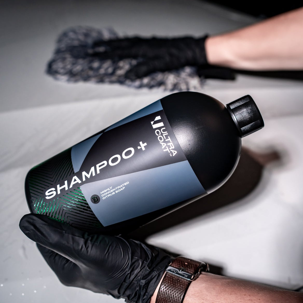 ULTRACOAT Shampoo+ bottle held above active foam